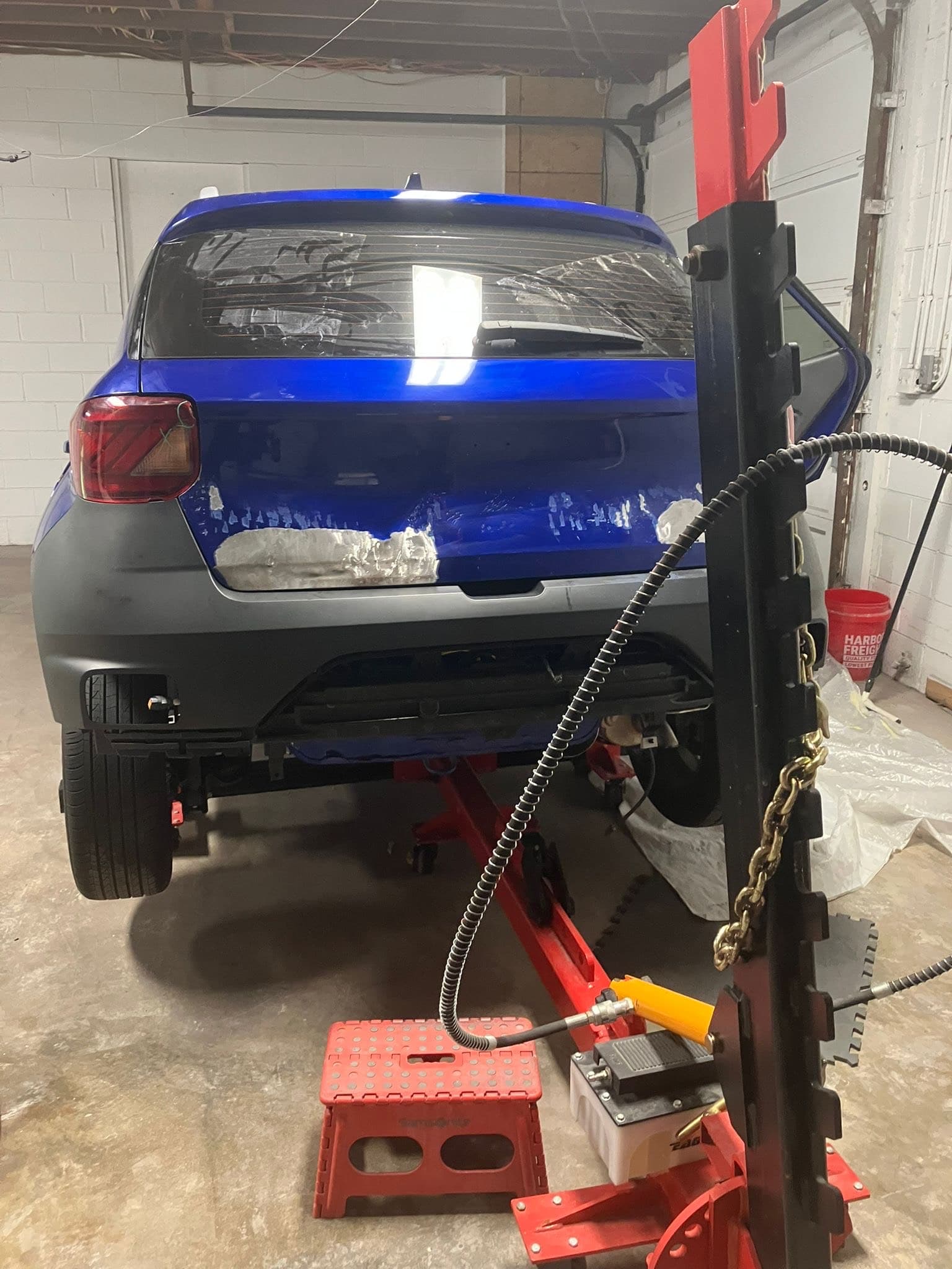 Hyundai Venue before repair showing rear-end damage on frame machine